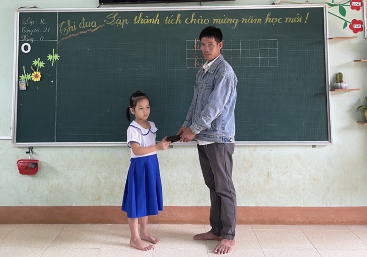 Cháu Nguyễn Ban Mai, học sinh lớp 1C, Trường Tiểu học Gio Châu, huyện Gio Linh, tỉnh Quảng Trị trả lại ví nhặt được cho người đánh mất.