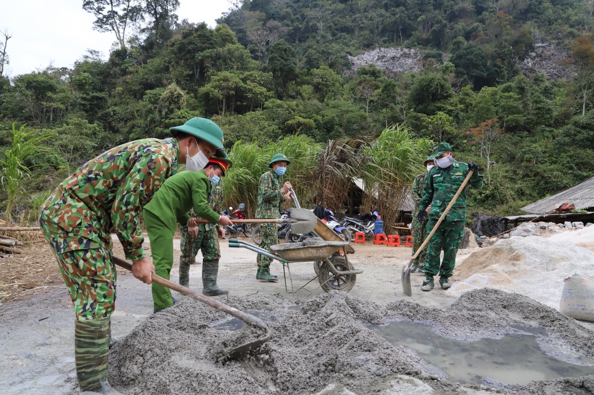 Cán bộ, chiến sĩ Đồn Biên phòng Sơn Vĩ giúp nhân dân xóa nhà tạm tại thôn Lũng Chỉn. Ảnh: hagiangtv.vn