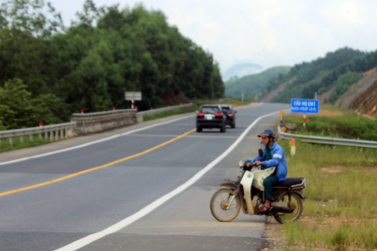 Người dân chạy xe máy băng qua cao tốc La Sơn -Túy Loan đoạn qua huyện Nam Đông, Thừa Thiên Huế