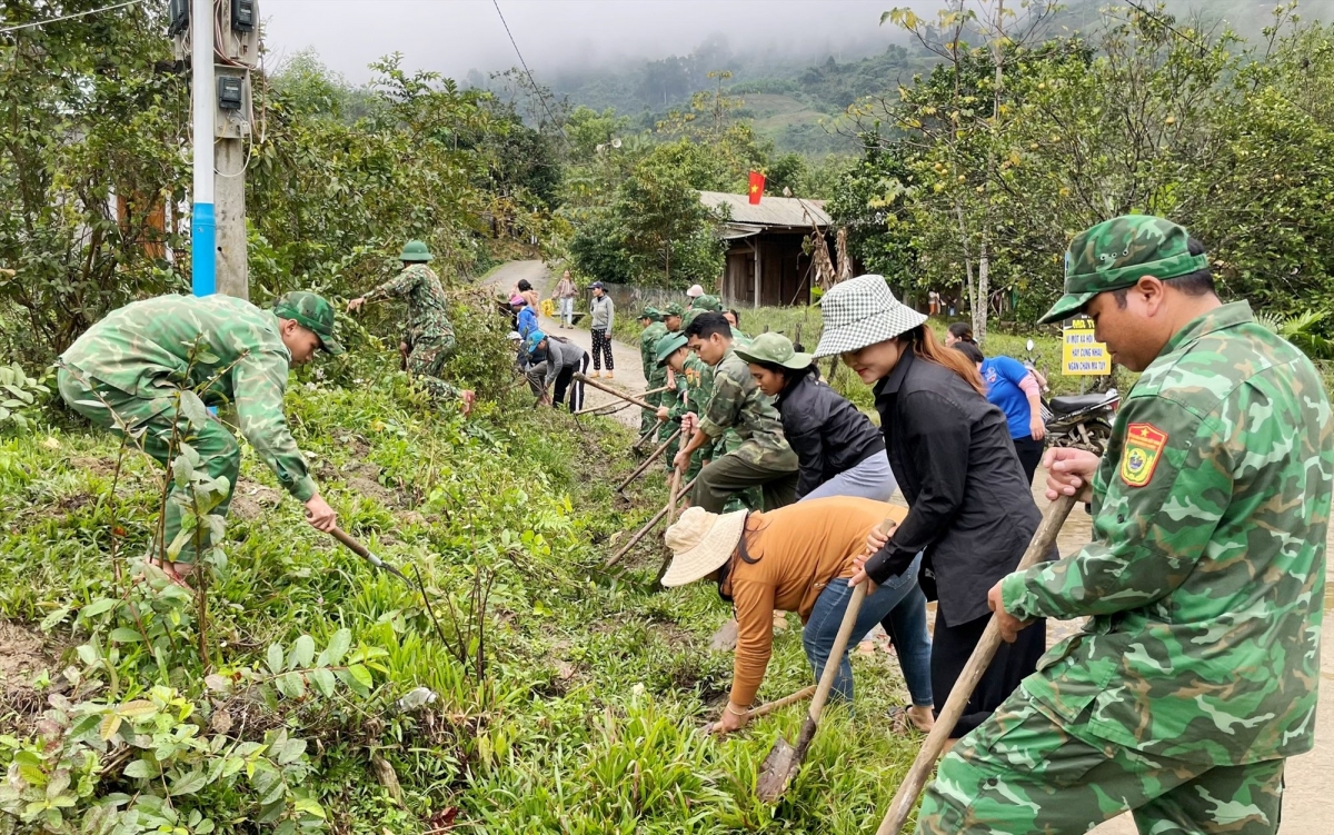 Cán bộ, chiến sĩ Đồn Biên phòng Đắc Pring giúp dân phát quang đường giao thông. Ảnh: VĂN VINH