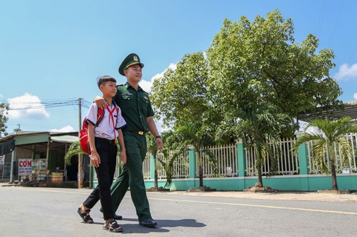 Em Huỳnh Văn Vương, học sinh lớp 8A1 thuộc‎ Trường Trung học cơ sở Tân Hoà, xã Tân Hoà, huyện Tân Châu được Trung uý Nguyễn Đình Đức, Đội trưởng Đội Vận động Quần chúng Đồn Biên phòng Tống Lê Chân đưa đến lớp. Ảnh: Giang Phương – TTXVN