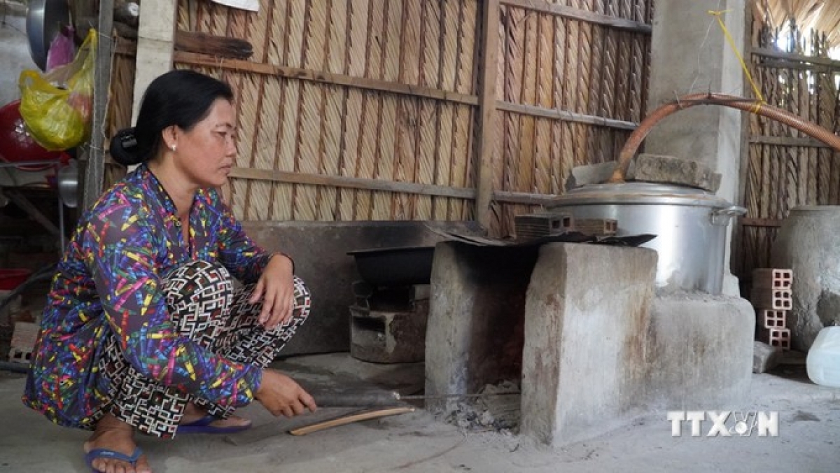 Bà Thị Sóc Khe, xã Thới Quản, huyện Gò Quao nấu rượu để nuôi lợn nhờ vốn vay của Hội Phụ nữ xã. Ảnh: Văn Sĩ - TTXVN
