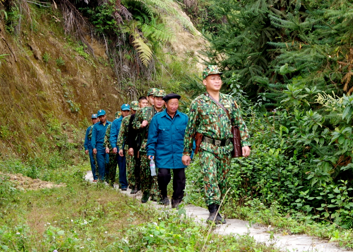 Người uy tín ở xã Bản Máy cùng với cán bộ chiến sỹ Đồn biên phòng Bản Máy đi tuần tra bảo vệ đường biên, mốc giới. Ảnh KT: Nguyễn Công Giang-Báo Biên phòng