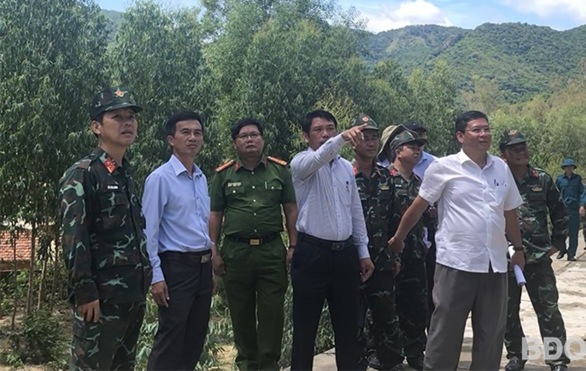 Đại tá Đỗ Xuân Hùng (bên trái) và thành viên tổ kiểm tra, lãnh đạo UBND huyện Phù Cát thị sát núi Cấm - khu vực “nhạy cảm” sạt lở đất đá khi có mưa lớn diễn ra. Ảnh: TRỌNG LỢI