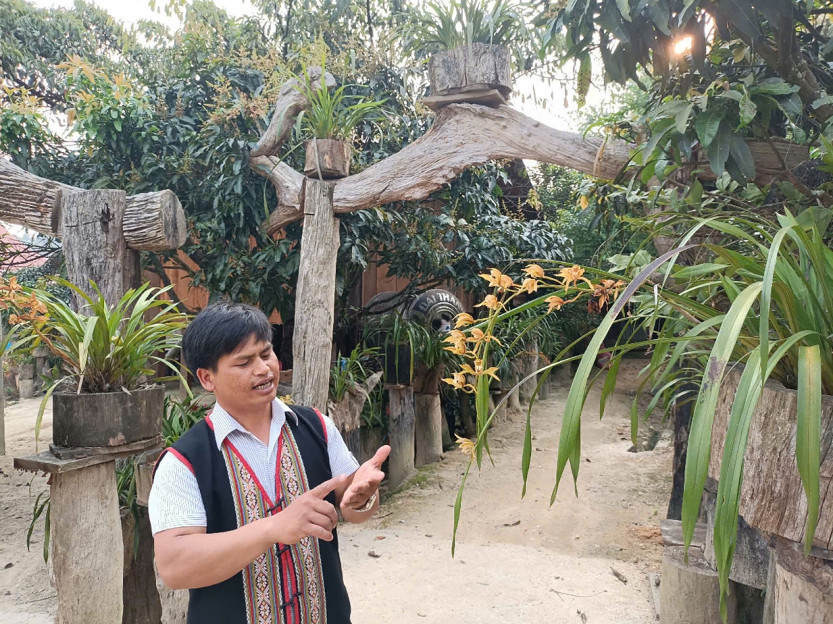 Anh A Hiền giới thiệu với khách du lịch về những loài lan mà dân làng Vi Rơ Ngheo đã bảo tồn nhân giống.