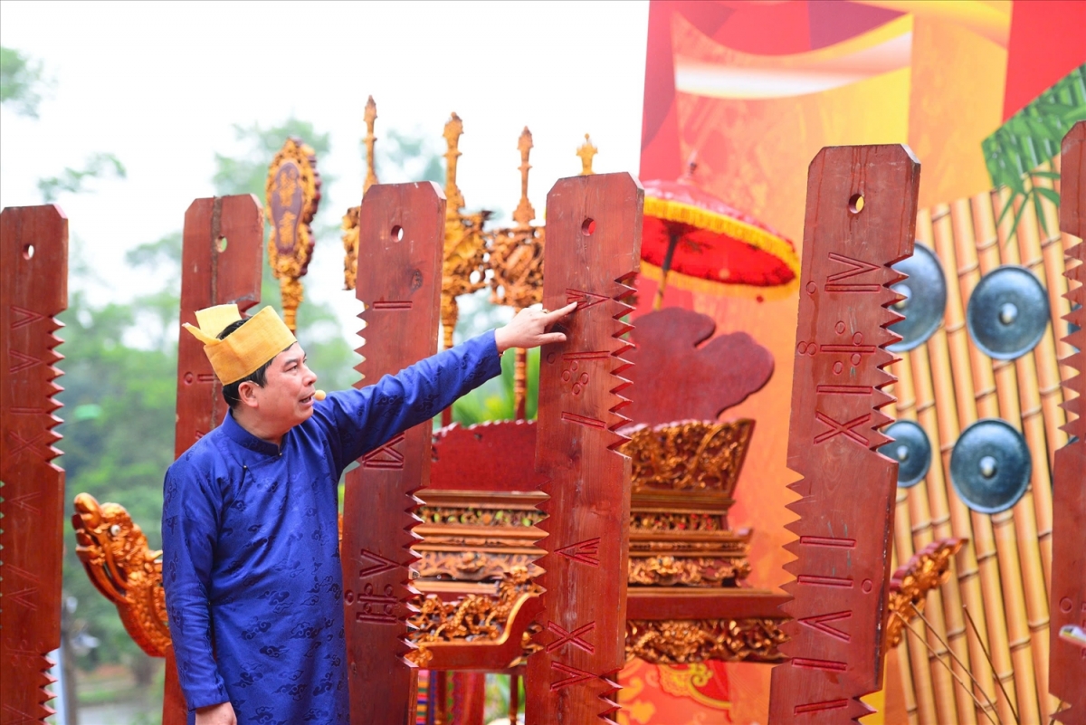 Nghệ nhân nhân dân Bùi Văn Minh Lịch Tre giới thiệu tại cách tính lịch tre đã được phóng đại để du khách quan sát rõ hơn