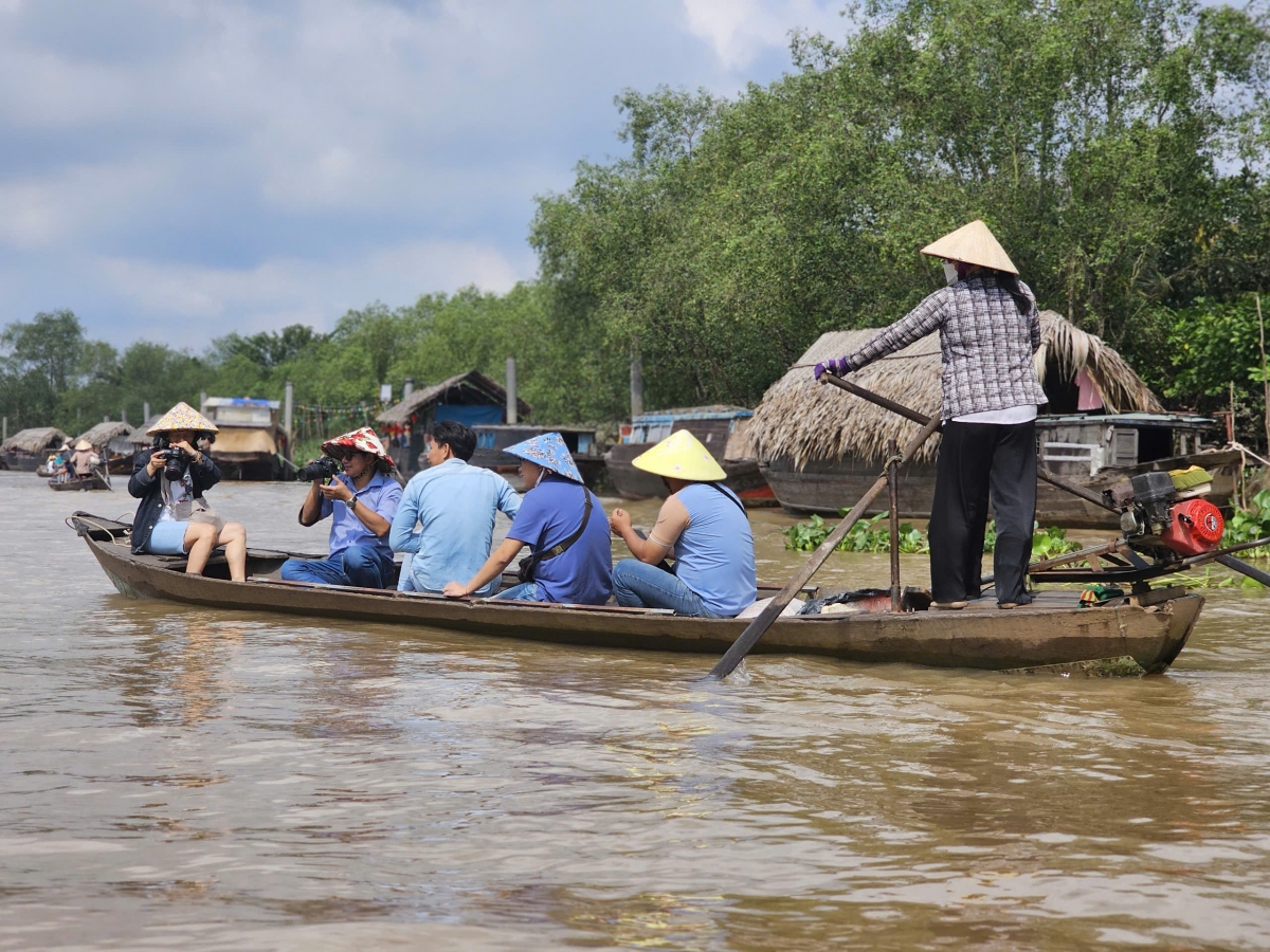 Khách du lịch thích thú chèo thuyền trên sông nước Vĩnh Long
