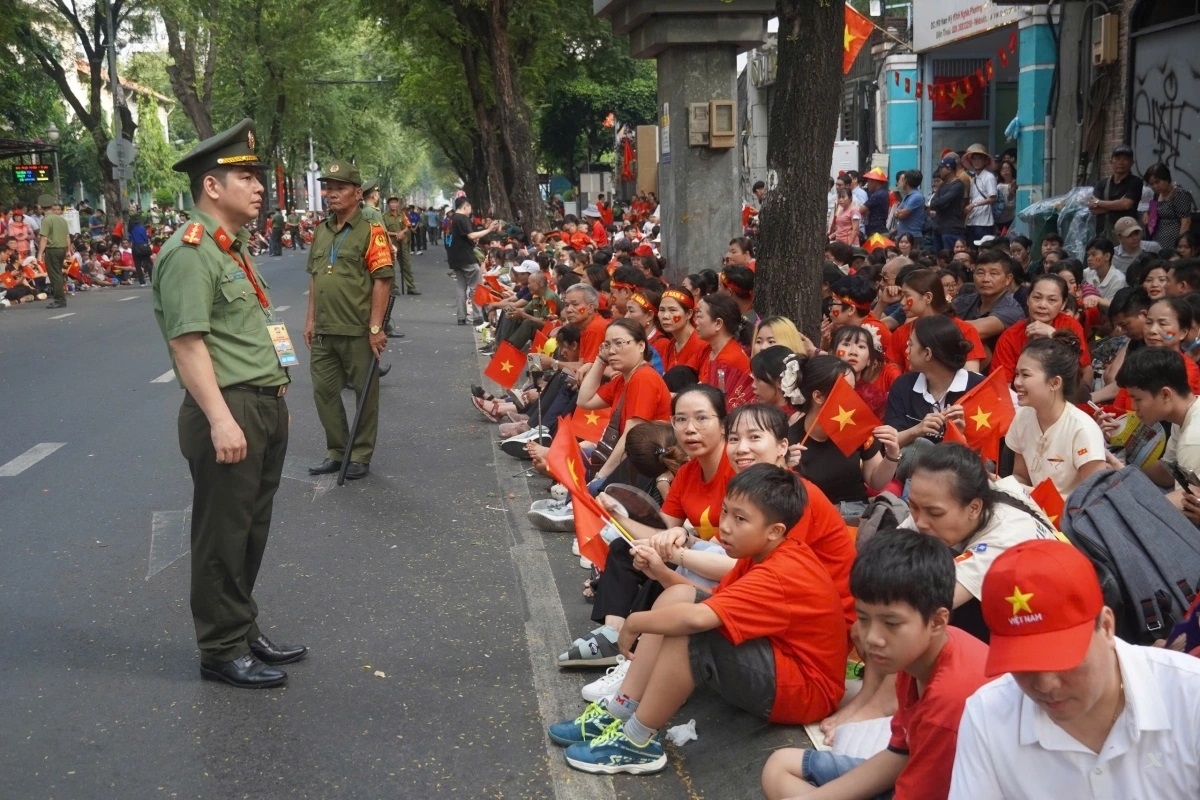 Mọi người ngồi trật tự 2 bên vỉa hè để chờ đợi các khối diễu binh, diễu hành.
