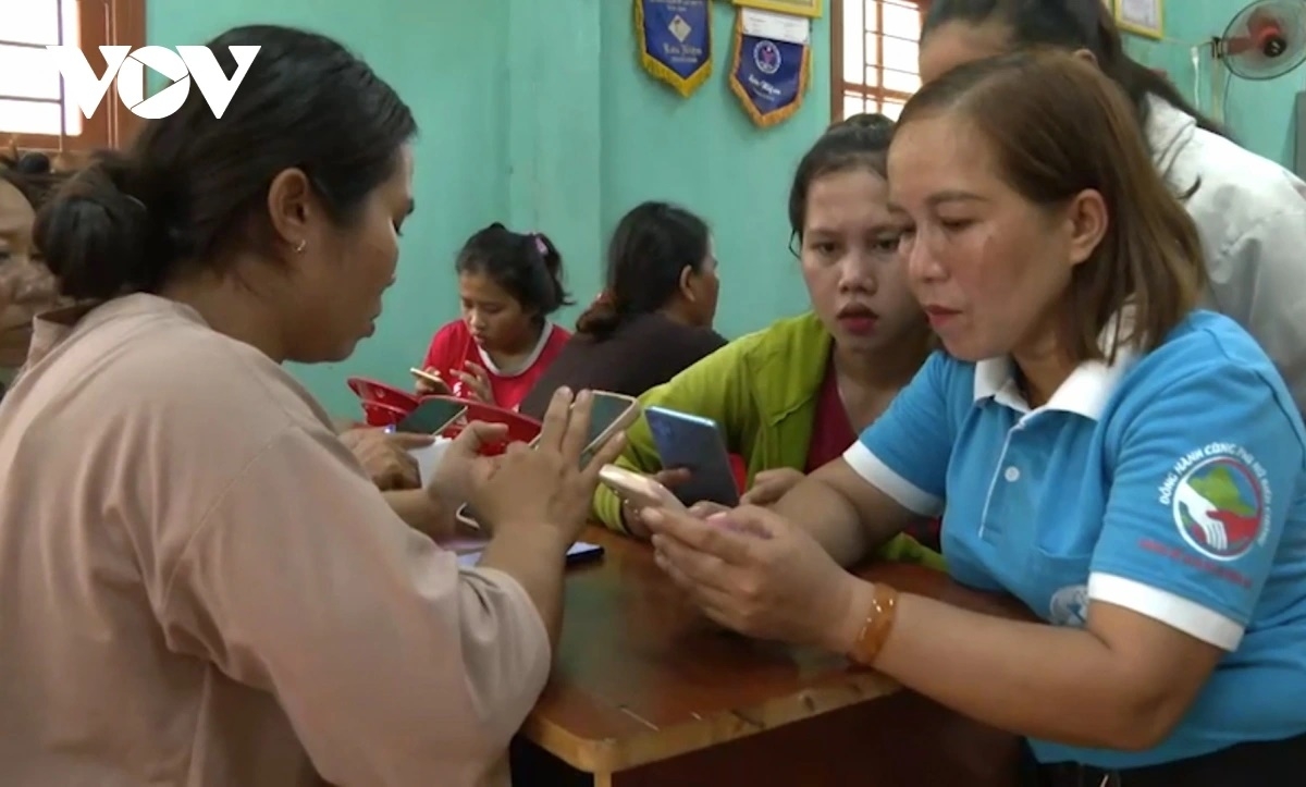Các thành viên tổ công nghệ số cộng đồng hướng dẫn người dân sử dụng dịch vụ công trực tuyến trên điện thoại.
