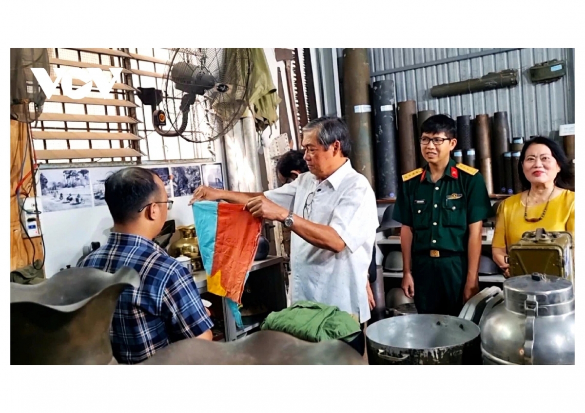 Ông Lê Lam Điền giới thiệu về lá cờ Mặt trận Dân tộc Giải phóng miền Nam Việt Nam. (Ảnh -Hữu Đặng)