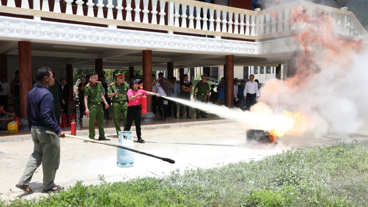 Công an xã Mà Cooih hướng dẫn người dân thực hành chữa cháy bằng bình cứu hỏa. Ảnh: VĂN LÃM