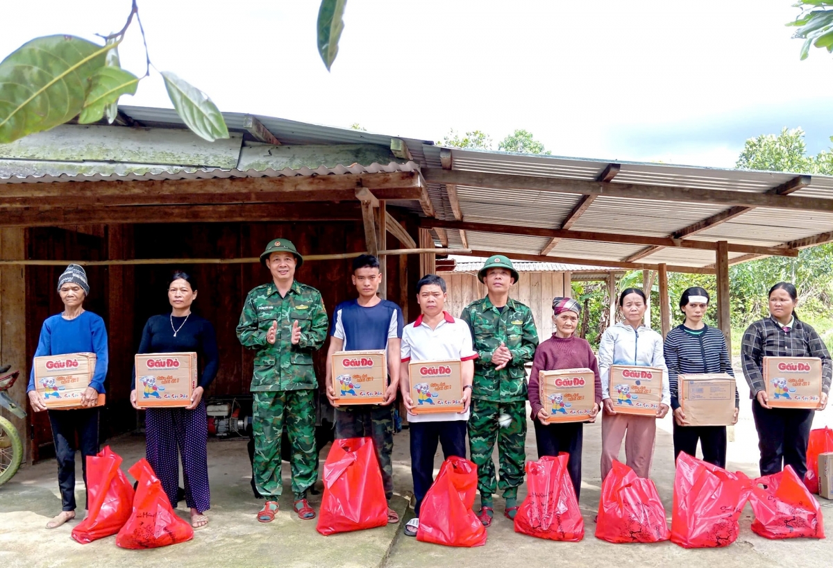 Ban Chỉ huy Đồn Biên phòng Đắc Pring tặng nhu yếu phẩm cho các hộ dân cụm dân cư Pêtapot. Ảnh: VĂN VINH