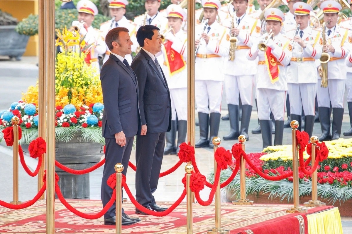 Chủ tịch nước Lương Cường chủ trì lễ đón Tổng thống Emmanuel Macron. Hai nhà lãnh đạo đứng trên bục danh dự, quân nhạc cử Quốc thiều hai nước.