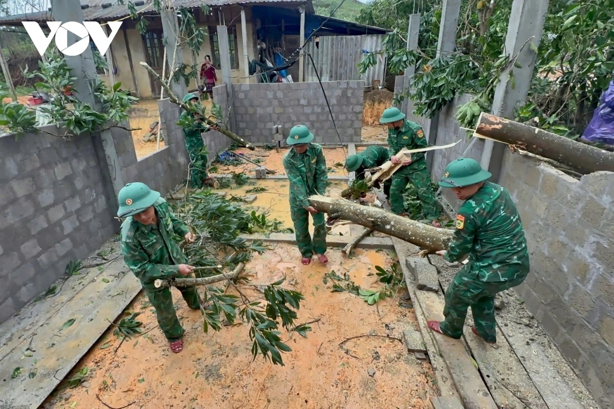 Cán bộ chiến sĩ Đồn Biên phòng cửa khẩu A Đớt hỗ trợ người dân dọn dẹp cây đổ gãy do lốc gây ra