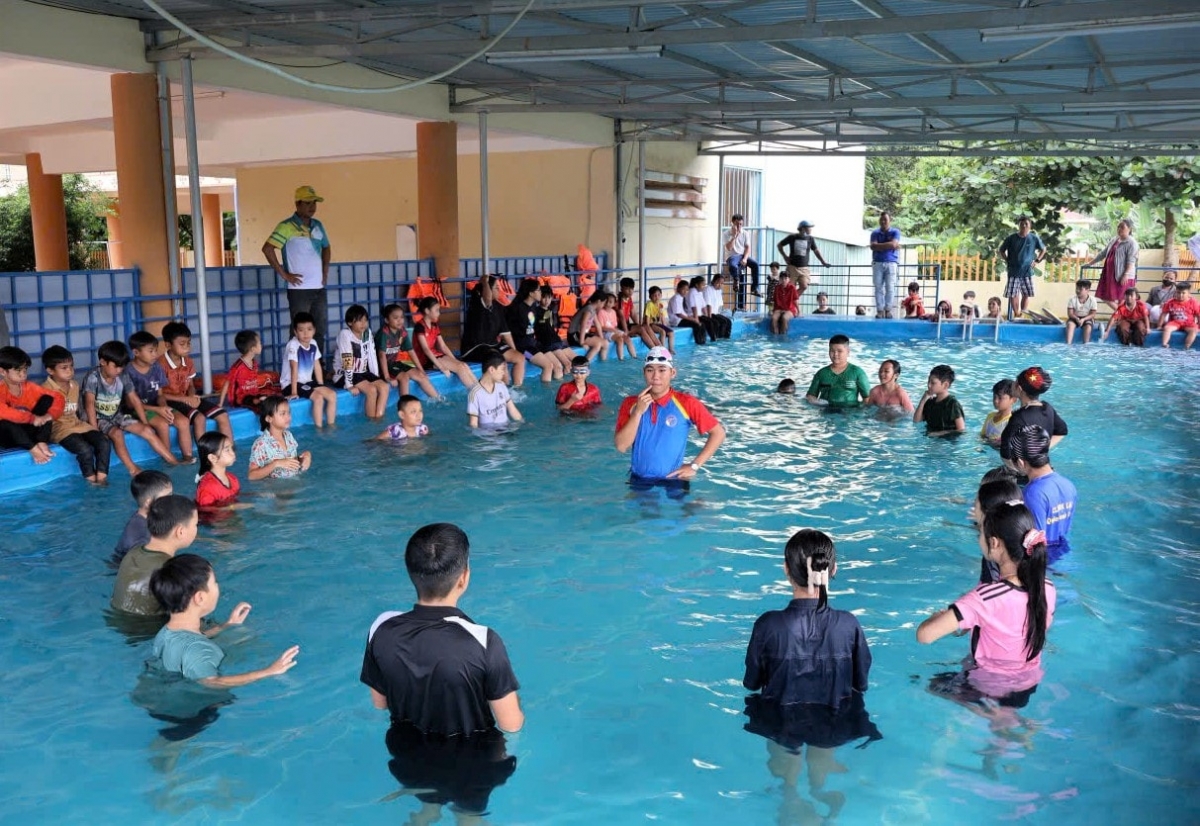 Trẻ em xã Đông Giang hào hứng tập bơi cùng huấn luyện viên. Ảnh: ĐĂNG NGUYÊN