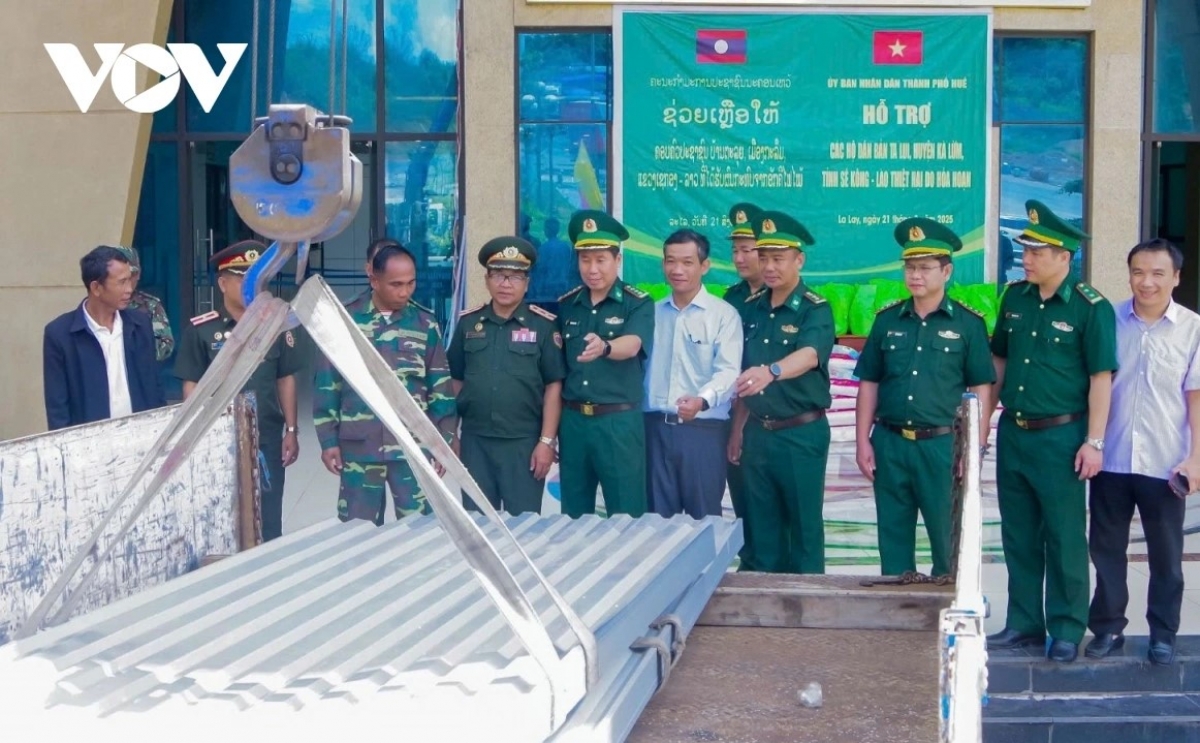 Trao tấm tôn lợp nhà tặng các hộ dân bản Tà Lụi (Lào) bị hỏa hoạn.