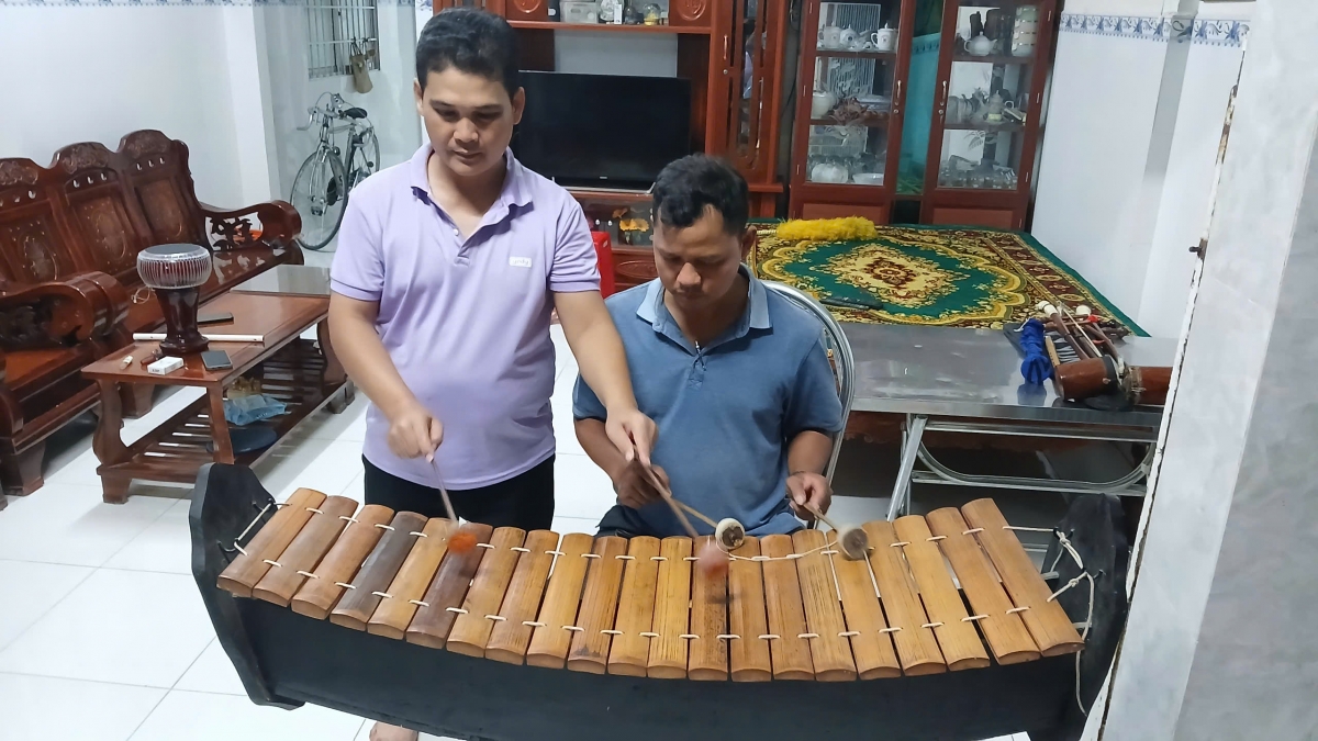 Anh Chơne Sô Pha Ra (Bên trái) đang tận tình hướng dẫn học viên chơi nhạc cụ rô niêt ek