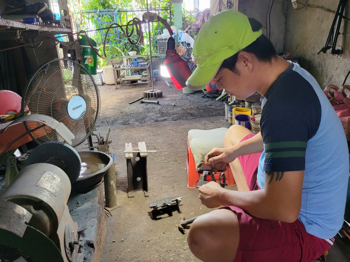Anh Phan Lê Sỹ con trai ông Dũng đang thực hiện một công đoạn để sản xuất chiếc máy dập chì