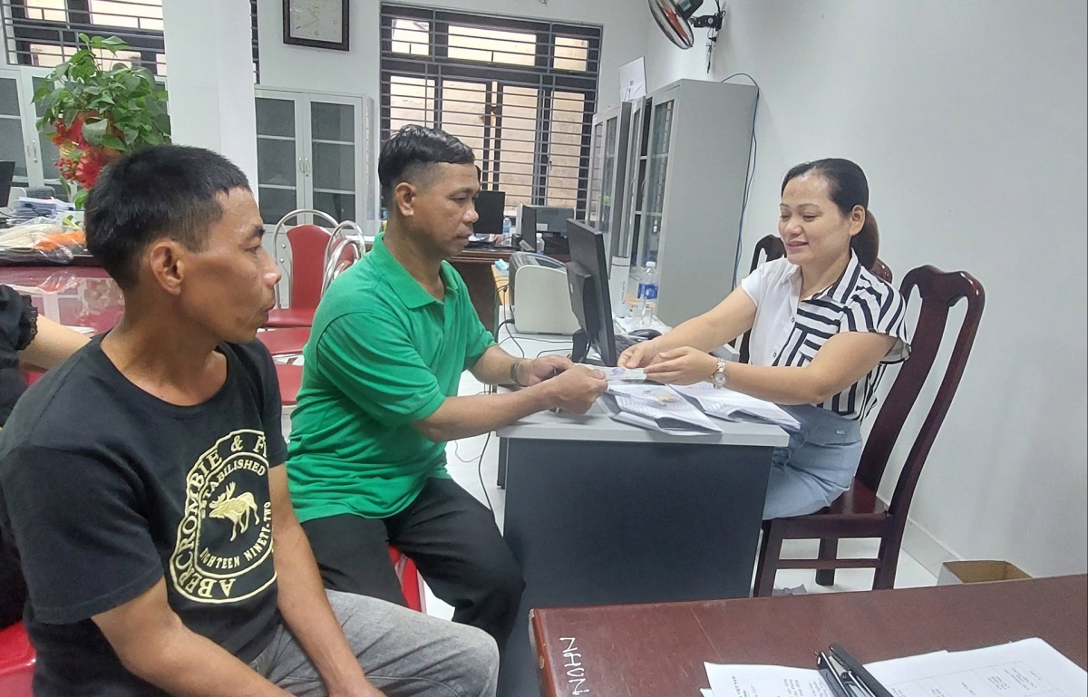 Cán bộ phường Hải Vân làm việc ngoài giờ hành chính để chi tiền trợ cấp cho người dân. Ảnh: TRỌNG HÙNG