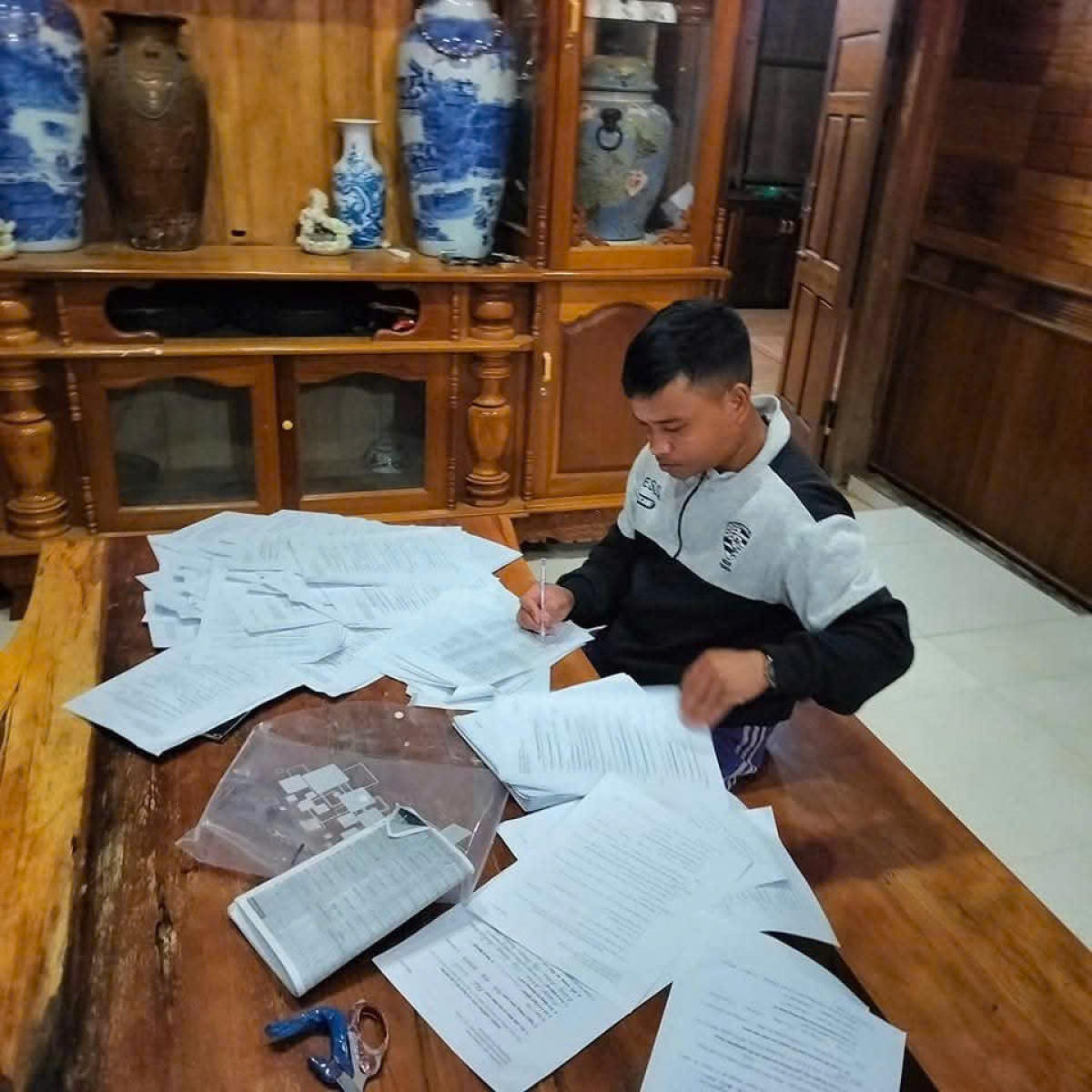 Anh Hôih Tèo tranh thủ buổi tối giải quyết công việc của thôn 