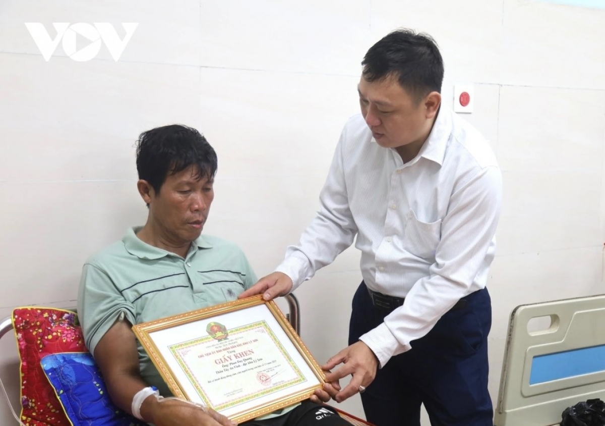 Ông Nguyễn Văn Huy, Chủ tịch UBND đặc khu Lý Sơn, tỉnh Quảng Ngãi trao giấy khen tặng ông Phan Duy Quang.