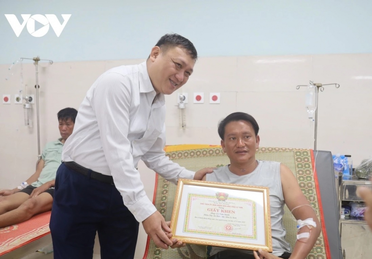 Ông Nguyễn Văn Huy, Chủ tịch UBND đặc khu Lý Sơn, tỉnh Quảng Ngãi trao giấy khen tặng anh Lê Văn Sanh vì có hành động dũng cảm cứu người trong cơn bão số 13.