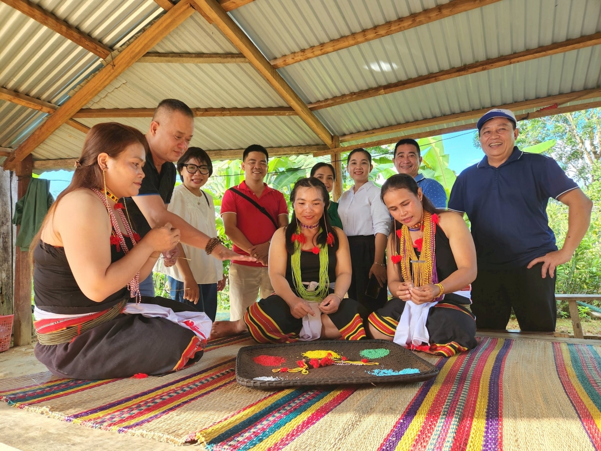 Du khách tìm hiểu hoạt động xâu hạt cườm của đồng bào Ca Dong (vùng núi Trà My). Ảnh: QUỐC TUẤN