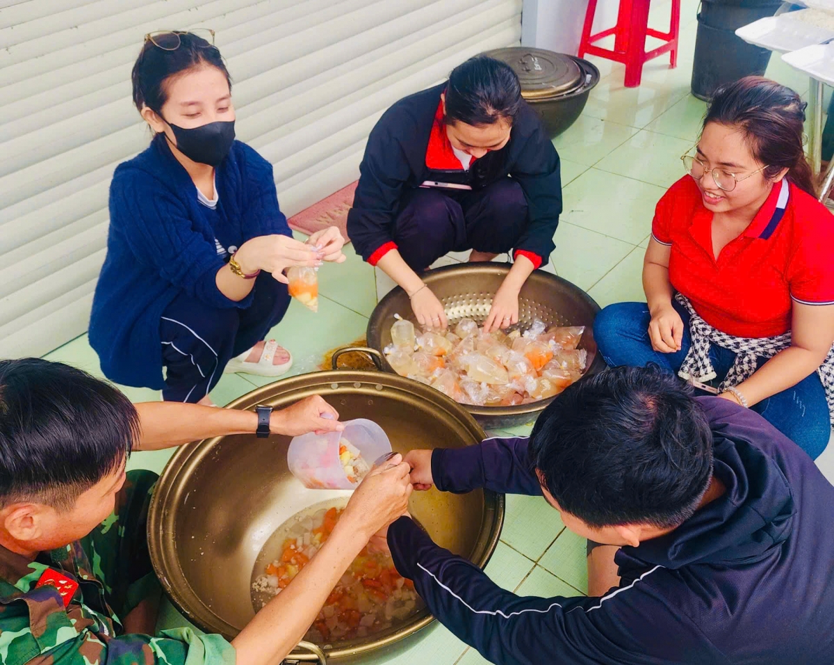  Các tổ chức đoàn thể cùng cán bộ phụ trách xe bếp giúp bà con vùng lũ có những hộp cơm nóng