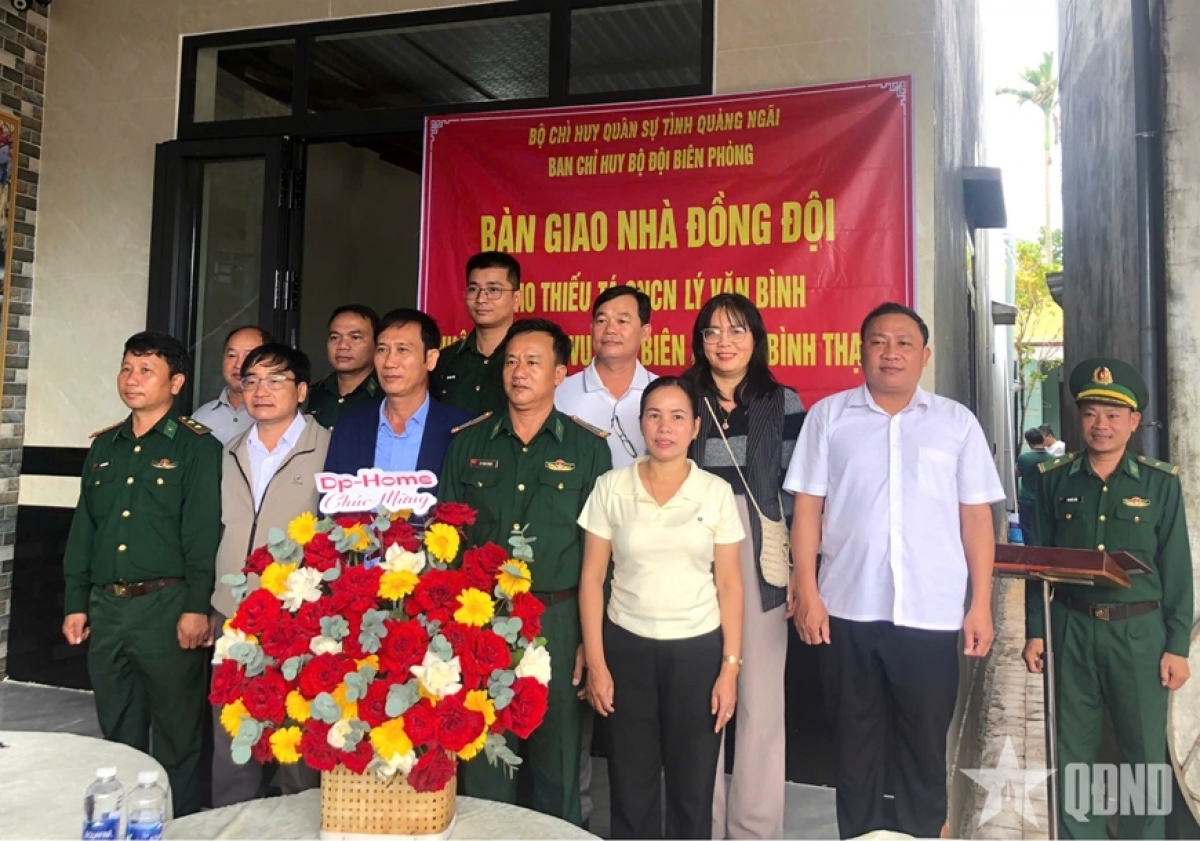 Các đại biểu dự bàn giao nhà và gia đình Thiếu tá QNCN Lý Văn Bình. Ảnh Báo Quân đội