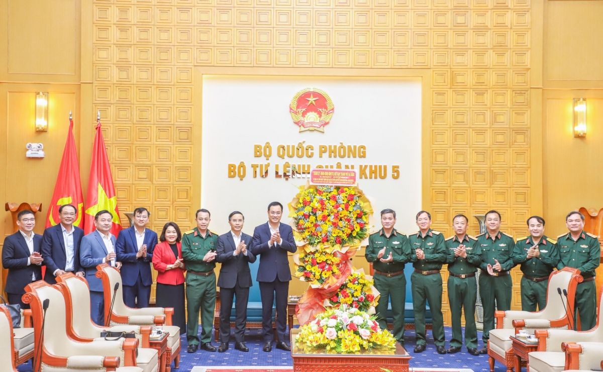 Bí thư Thành ủy Lê Ngọc Quang (thứ 8, bên trái sang) và Chủ tịch UBND thành phố Phạm Đức Ấn (thứ 7, bên trái sang) tặng hoa chúc mừng Quân khu 5 nhân kỷ niệm 81 năm Ngày thành lập Quân đội nhân dân Việt Nam. Ảnh: NGỌC PHÚ