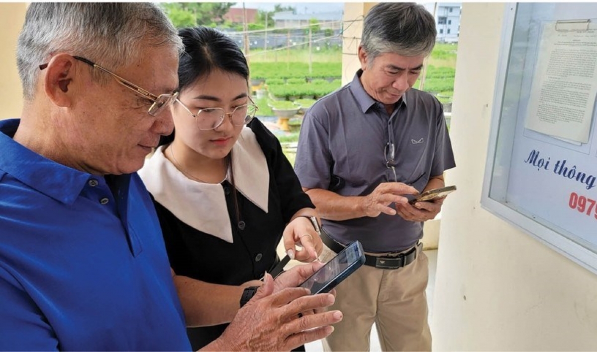 Thành viên Tổ công nghệ số cộng đồng hướng dẫn người dân sử dụng các nền tảng số trên điện thoại thông minh. Ảnh: Báo Văn hoá