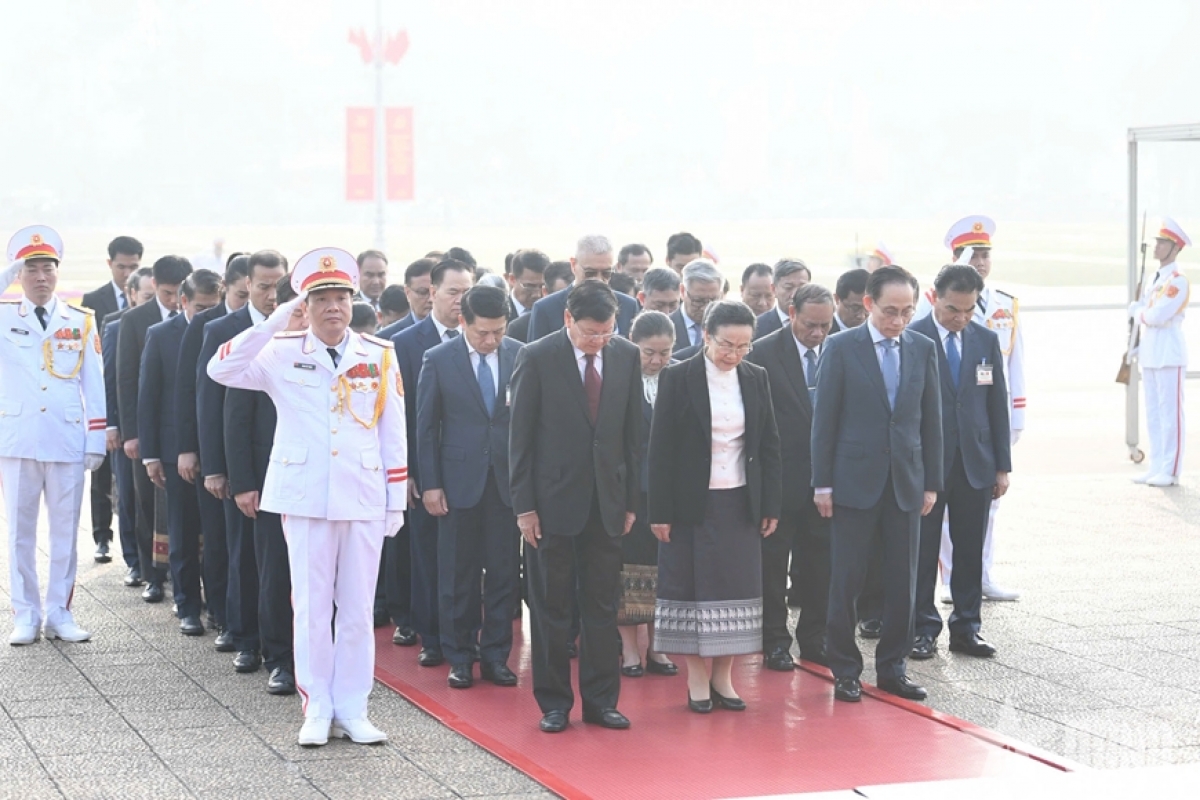 Tổng Bí thư, Chủ tịch nước Lào Thongloun Sisoulith và phu nhân cùng đoàn đại biểu cấp cao Đảng, Nhà nước Lào đặt vòng hoa viếng Chủ tịch Hồ Chí Minh. Ảnh: TRỌNG HẢI