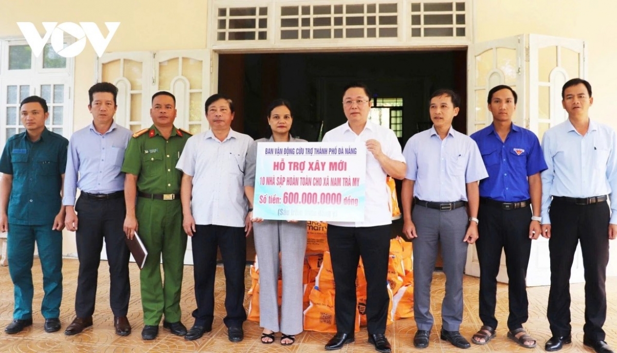 Ông Lê Trí Thanh, Chủ tịch Ủy ban Mặt Trận Tổ Quốc Việt Nam TP Đà Nẵng (thứ 4 từ phải qua) trao kinh phí hỗ trợ làm nhà tặng người dân xã Nam Trà My.