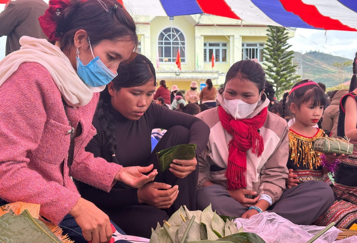 Các em học sinh được thầy cô và phụ huynh hướng dẫn các công đoạn gói bánh chưng.