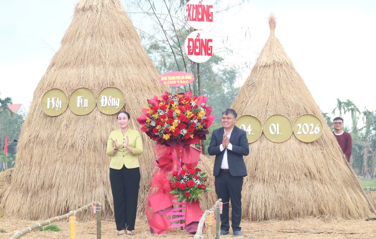 Phó Chủ tịch UBND thành phố Nguyễn Thị Anh Thi trao (bên trái) tặng hoa chúc mừng Lễ hội xuống đồng Hội An Đông năm 2026.