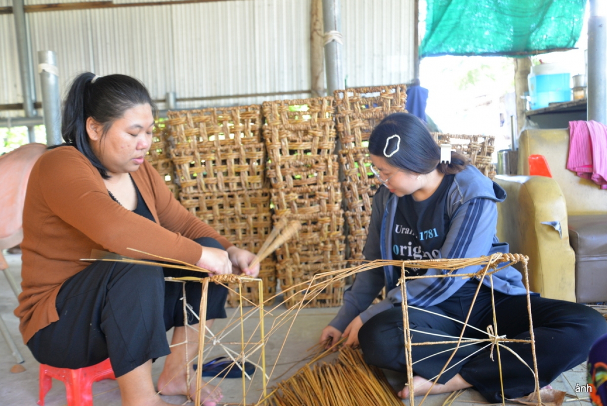 hơn chục lao động là chị em phụ nữ ở nhiều độ tuổi đang cần mẫn đan các sản phẩm thủ công mỹ nghệ