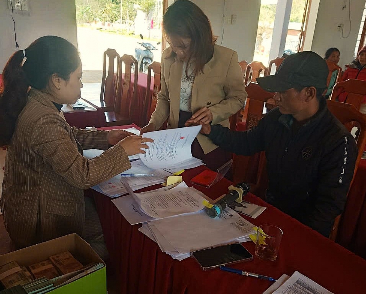 Các hộ dân xã Trà Giáp làm thủ tục nhận kinh phí hỗ trợ xóa nhà tạm, nhà dột nát sau khi công trình hoàn thiện và được nghiệm thu. Ảnh: NGUYỄN BÌNH