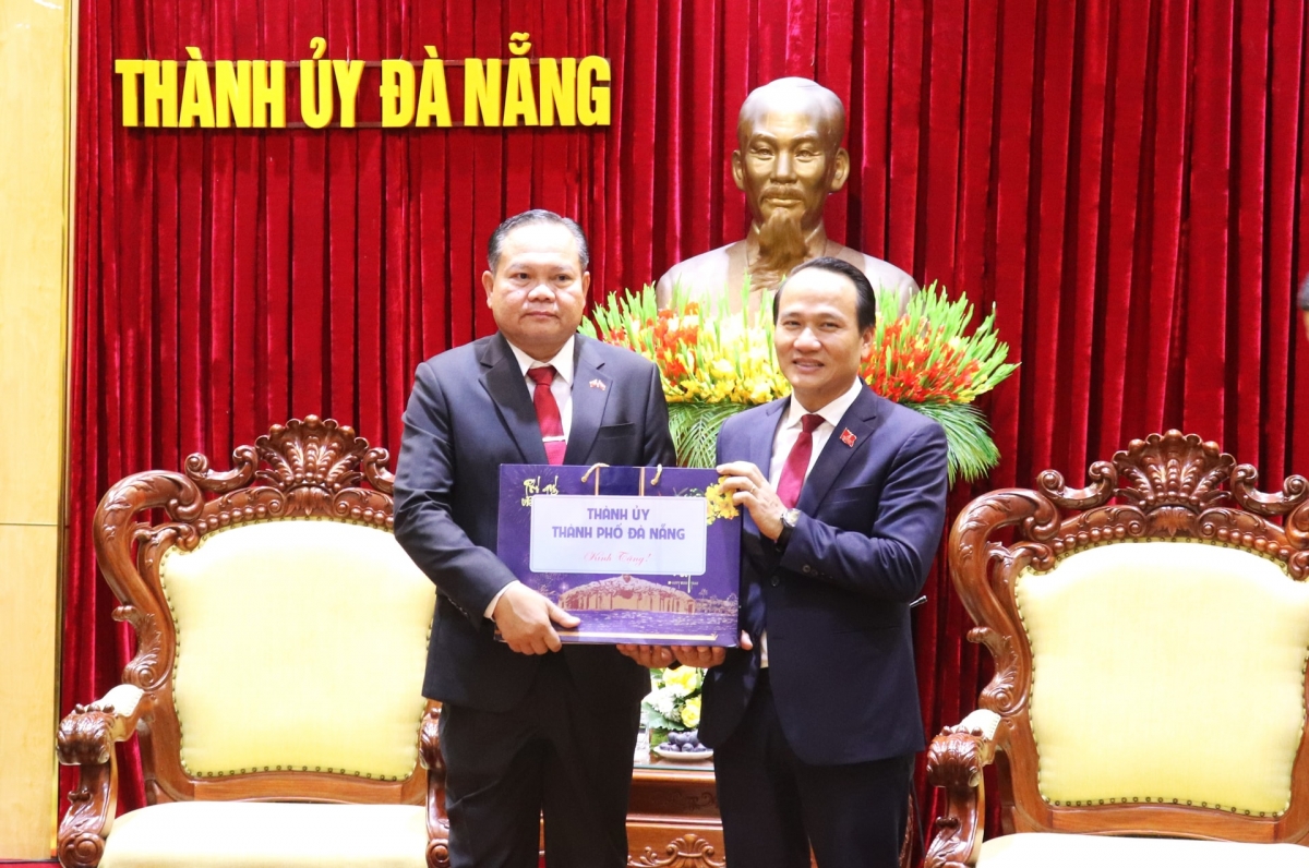 Phó Bí thư Thường trực Thành ủy Nguyễn Đình Vĩnh (bên phải) tặng quà lưu niệm cho Phó Bí thư Thường trực Tỉnh ủy Champasak Souphap Thammahacksa. 