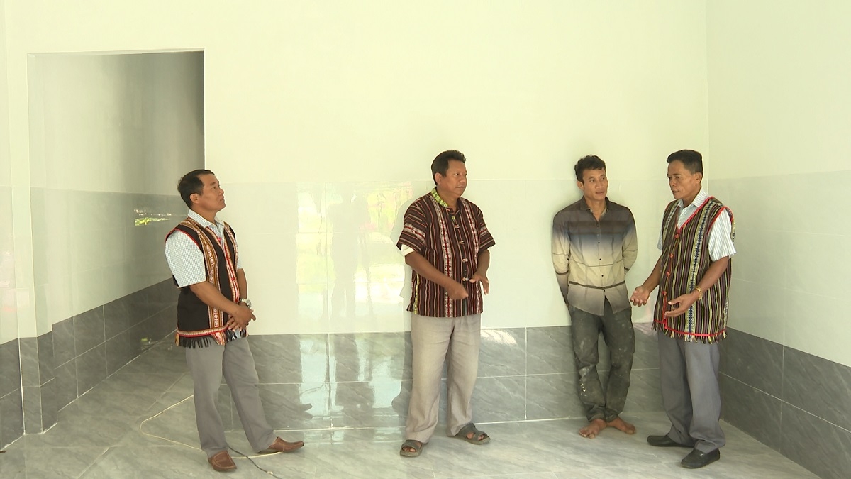 Ông Mang Mu (ngoài cùng bên phải) thăm hộ gia đình nghèo vừa làm xong nhà mới