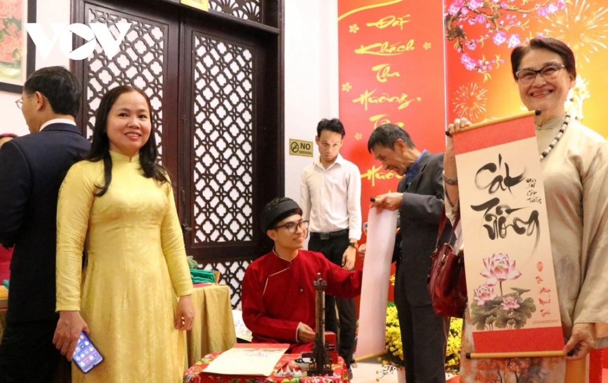 Bà con kiều bào và đại biểu thích thú với thư pháp Việt.