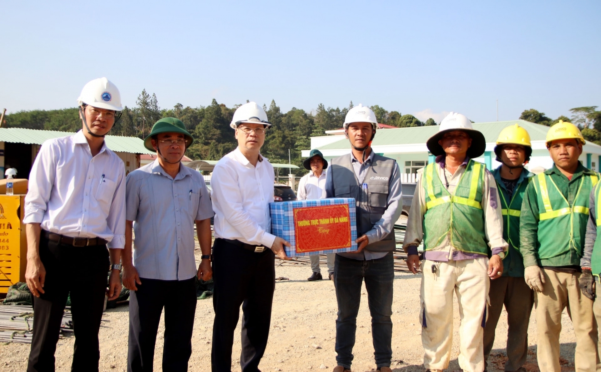 Phó Bí thư Thành ủy Nguyễn Mạnh Hùng (bên trái) tặng quà động viên công nhân làm việc trên công trường dự án Trường phổ thông nội trú liên cấp Tiểu học và THCS xã Tây Giang. Ảnh: TRỌNG HUY