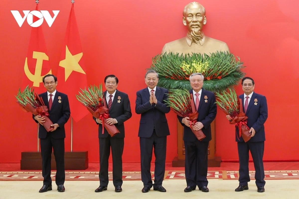 Tổng Bí thư Tô Lâm tặng hoa chúc mừng các đồng chí được nhận Huân chương Quân công hạng nhất.