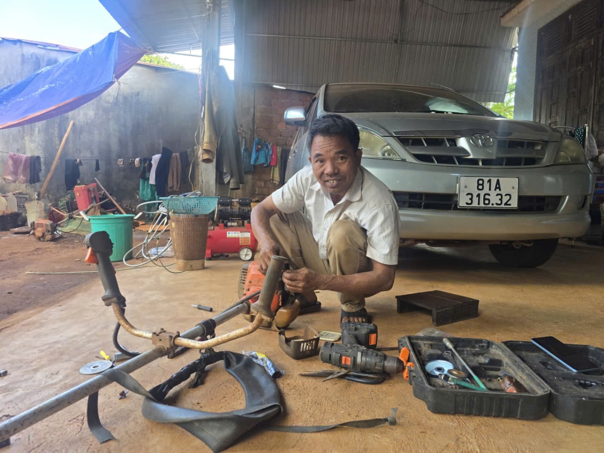 Ông Ksor Bư sửa lại máy cắt cỏ để chuẩn bị lao động đầu năm mới