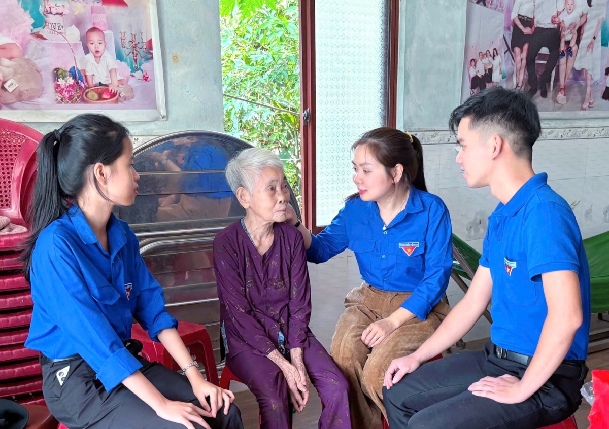 Đoàn viên thanh niên xã Hiệp Đức thăm hỏi, trò chuyện với người có công cách mạng. Ảnh: LAM PHƯƠNG