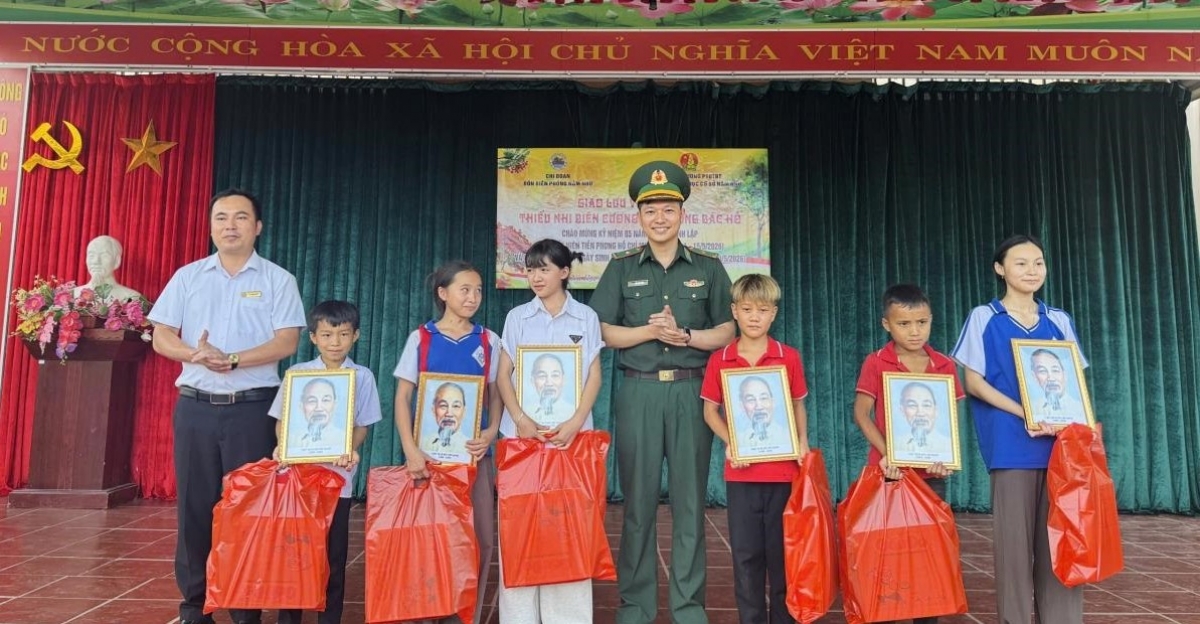 Đồn biên phòng Nậm Nhừ trao quà và ảnh Bác Hồ cho gia đình các cháu thiếu nhi (Ảnh: Mùa Tùng)