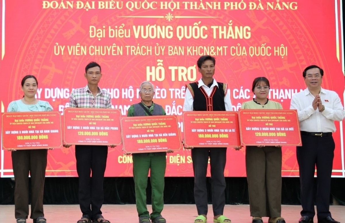 Ông Vương Quốc Thắng (bên phải) cùng lãnh đạo Công ty Thủy điện Sông Bung trao hỗ trợ nhà ở cho đại diện các hộ dân.