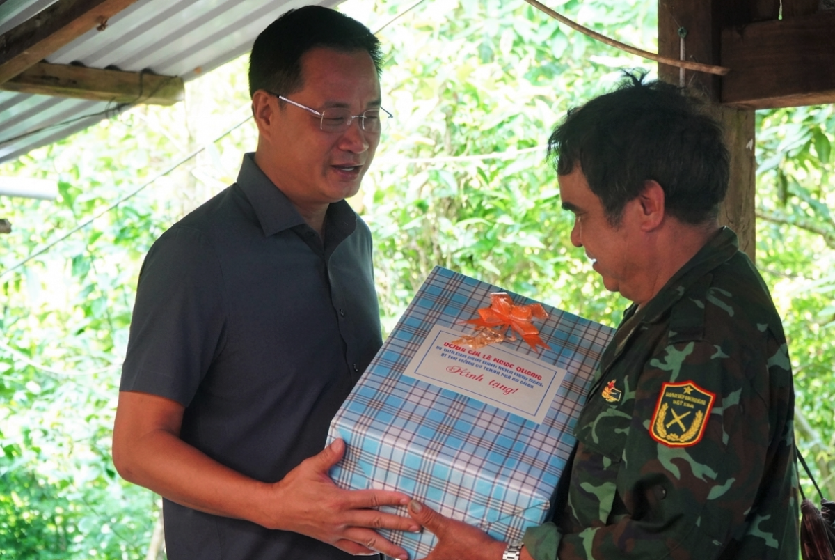 Bí thư Thành ủy Lê Ngọc Quang (bên trái) tặng quà cho ông Hồ Văn Du, một hộ trồng sâm tiêu biểu ở xã Trà Linh. Ảnh: VINH ANH