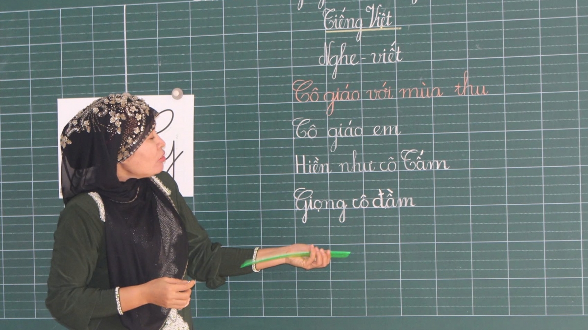 Cô giáo Thị Saly Has giải thích bằng tiếng Chăm rồi hướng dẫn em đọc theo từng âm tiếng Việt. (Ảnh: Nguyễn Quang)
