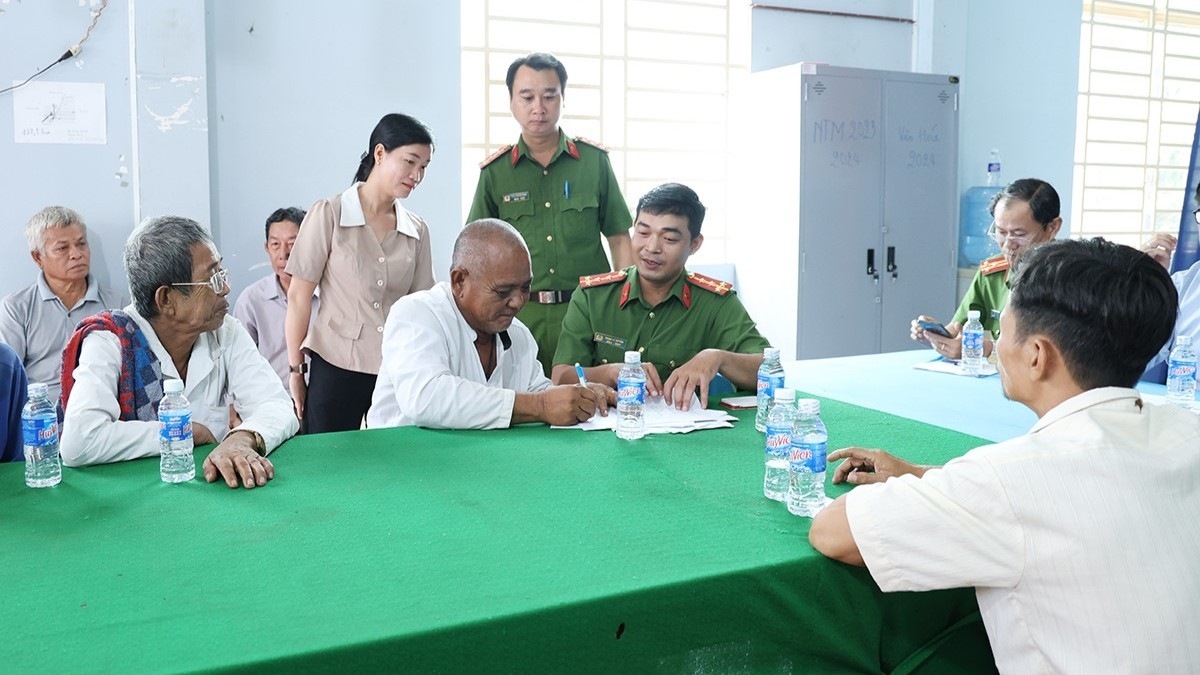 "Người dân xã An Cư ký cam kết thực hiện '5 không' với ma túy dưới sự chứng kiến của lực lượng Công an." (Ảnh: Tiến Tầm).