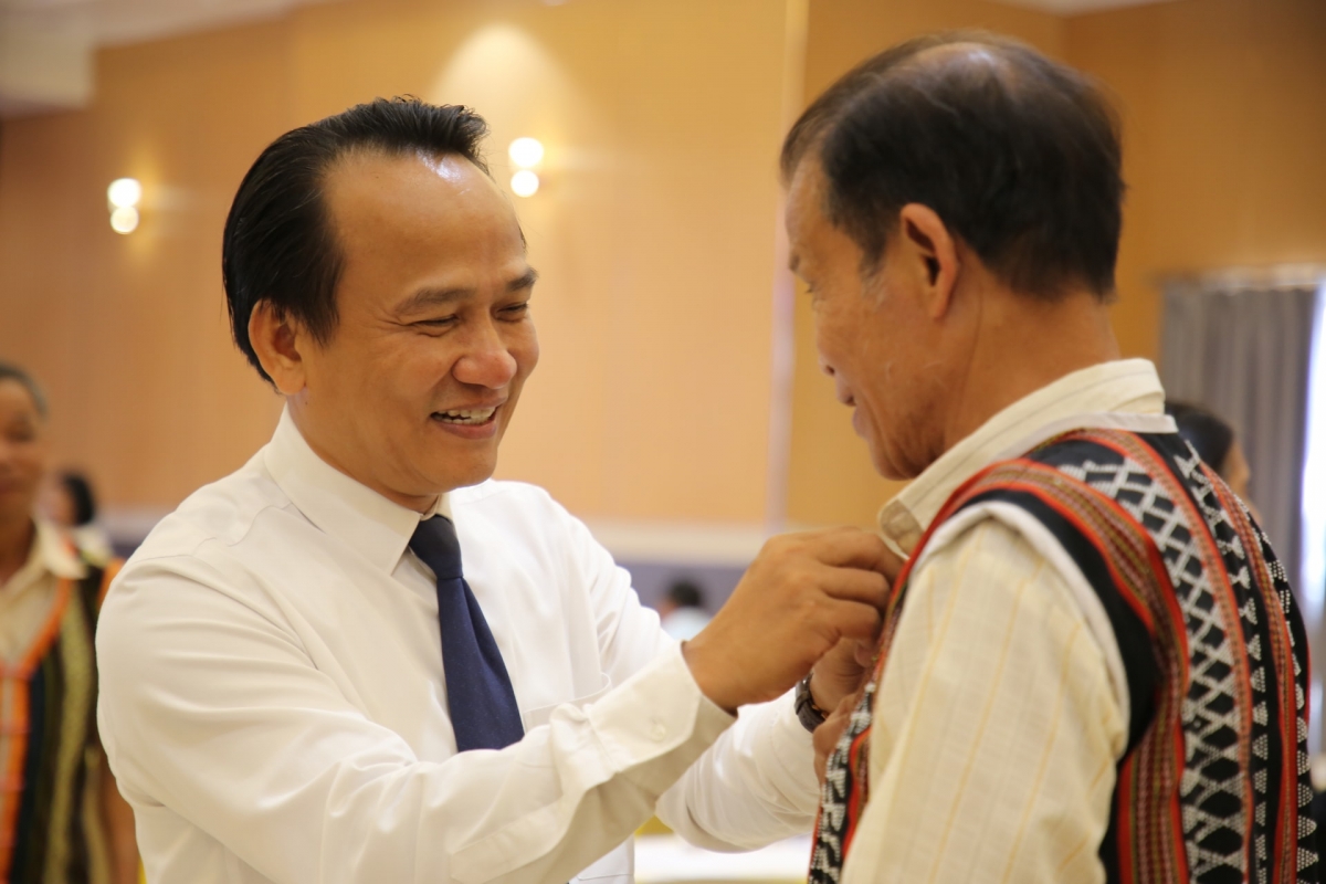 Phó Bí thư Thường trực Thành ủy Nguyễn Đình Vĩnh trò chuyện thân mật với người có uy tín tham dự hội nghị. Ảnh: ALĂNG NGƯỚC